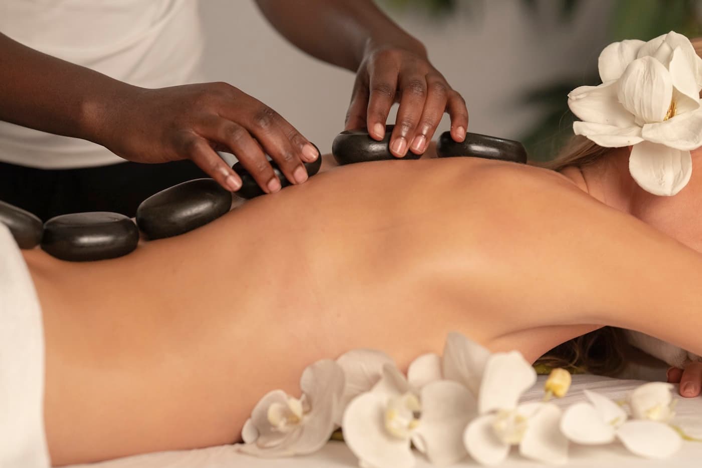 Heated basalt stones laid along a client's back during a healing stone treatment.