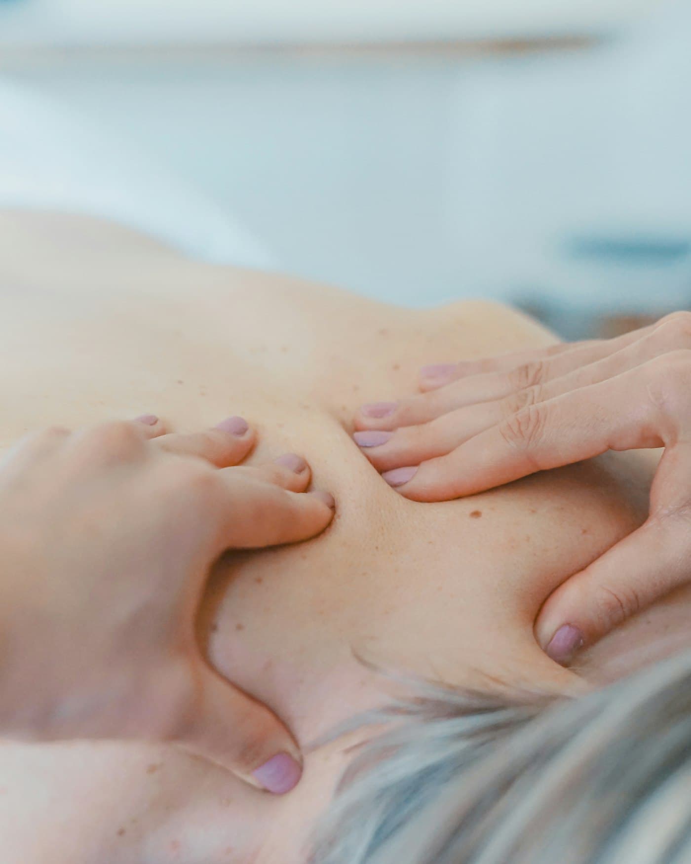 Focused pressure being applied to a client's shoulder and neck.